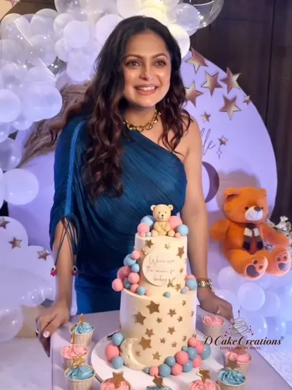 A joyous Drashti Dhami posing with her custom baby shower cake and matching cupcakes. The theme was "We are over the moon for baby K."