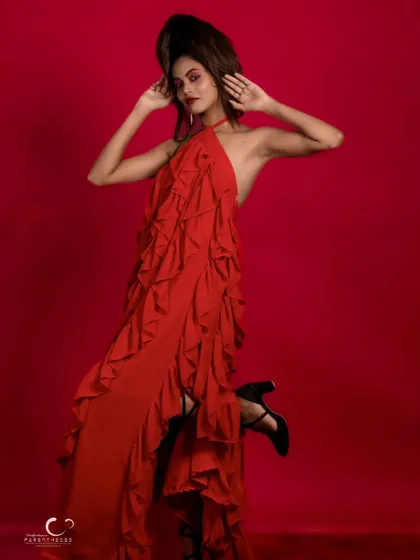 Another angle of the red gown, showing off the dramatic ruffles and the model's powerful stance.