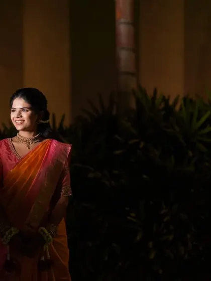 A wider portrait of the bride during her Haldi ceremony, set against a softly lit background. This shot captures the calm and happy ambiance of the pre-wedding ritual.