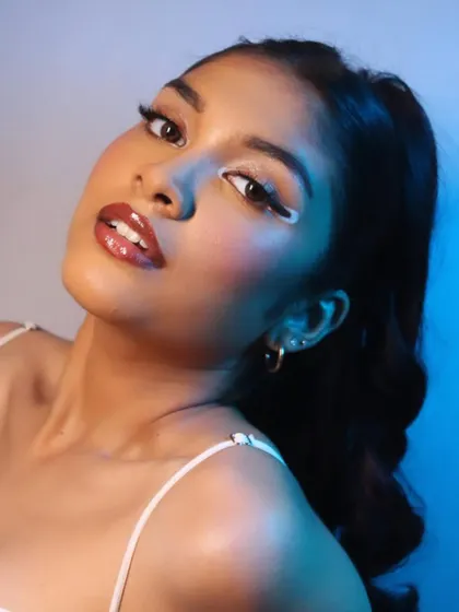 A dynamic angle that highlights the glossy lips and the sharp lines of the eye makeup.