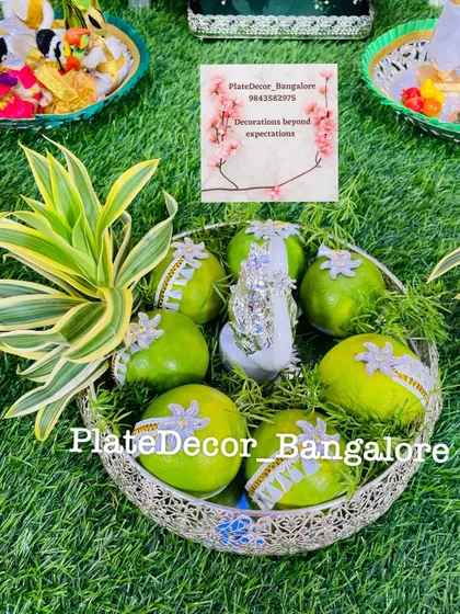 Sweet limes decorated with silver lace and a central swan figurine. The addition of fresh green leaves makes the arrangement look very fresh.