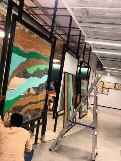 My team carefully installing one of the finished tapestry frames in the corporate office.