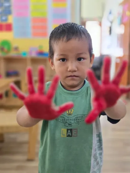This little Aster is focused and ready to create his handprint art. These simple activities help children develop their concentration and express their creativity.