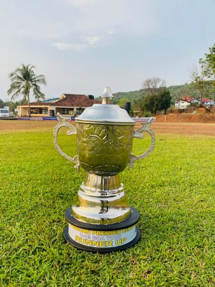 The runner-up trophy for the Goa Premier League, standing tall on the lush green Arlem Ground. A symbol of a hard-fought tournament.