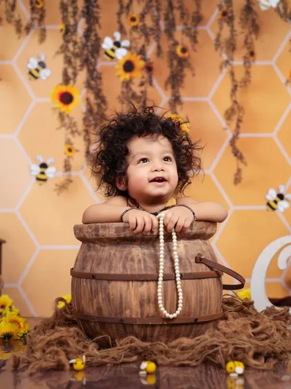 Another adorable shot of this little boy with curly hair, peeking out of a barrel in our honeybee setup.