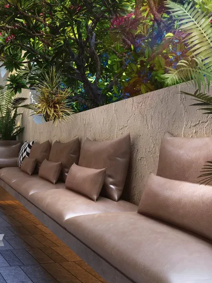 This seating nook at the Evara villa project in Igatpuri is nestled within a lush, tropical-inspired landscape. The design focuses on creating intimate, comfortable outdoor spaces that feel like a natural extension of the home's interior.