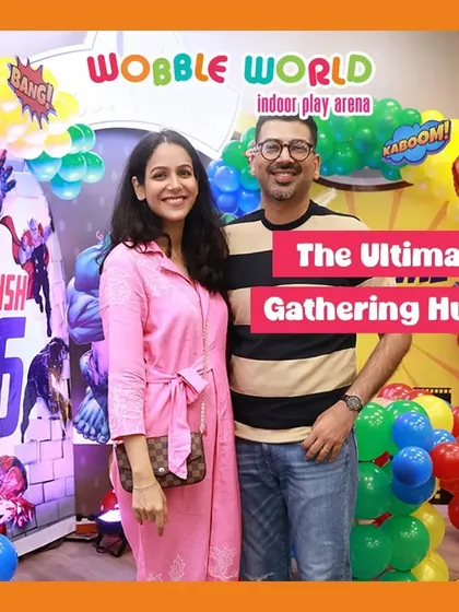 A couple standing proudly in front of their child's superhero party decor. We are the ultimate gathering hub for your family's special events.