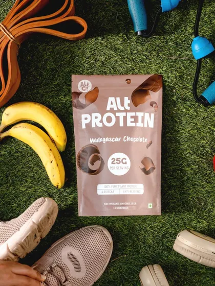 A flat lay for Alt Co.'s plant-based protein powder, surrounded by fitness equipment like running shoes and resistance bands. This lifestyle shot clearly positions the product as a key part of an active, healthy routine.
