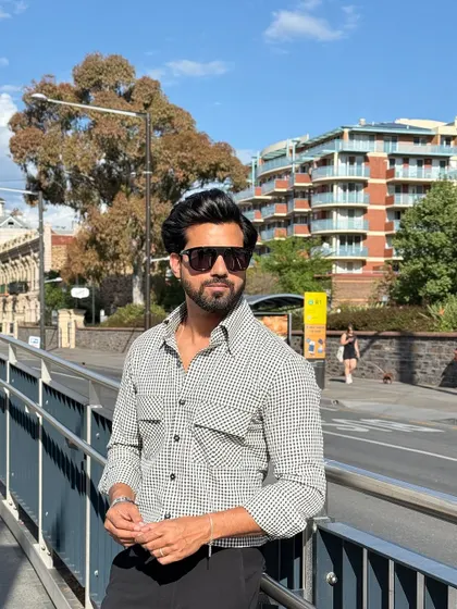 The check shirt seen in a bright, urban setting, showcasing its adaptability from day to night.