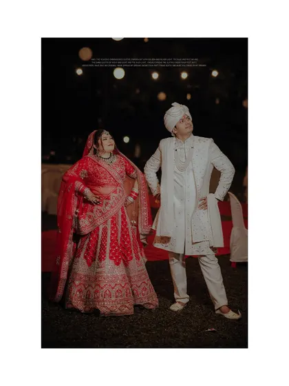 A fun and quirky portrait of the bride and groom under a canopy of lights, showcasing their playful personalities.