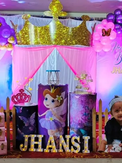 A royal celebration for a little princess. This fairy princess theme for Jhansi's first birthday includes a golden crown, character cutouts, and a pink and purple color palette.