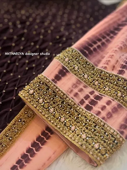 A close-up of the sleeve, featuring a heavily embroidered cuff on the tie-dye fabric.