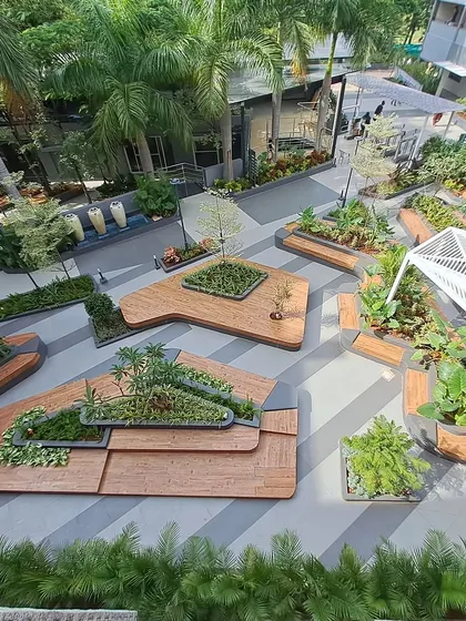 Another perspective of the Atria University campus landscape, showing the intricate layout of multi-level wooden platforms and integrated planters. This design creates a dynamic and visually engaging environment.
