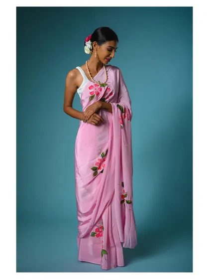 A full-length shot showing the elegant movement of the pink saree. This helps customers imagine how the fabric will feel and move.