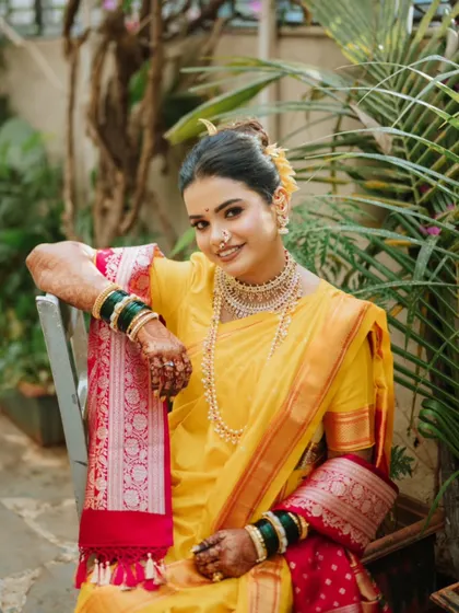 A portrait of a radiant bride in her yellow Paithani saree, a classic choice for Maharashtrian weddings.