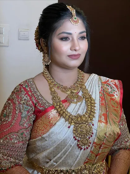 This look demonstrates how to work with intricate, heavy gold jewelry. The makeup is kept elegant and defined, with a focus on flawless skin and sharp eyes, allowing the traditional ornaments to shine.