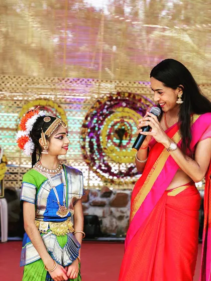 Engaging with a young artist on stage, making sure she feels celebrated.