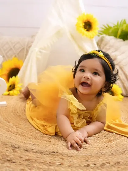 A happy baby girl crawling on a jute rug during her half-birthday session. These photos celebrate new physical milestones.