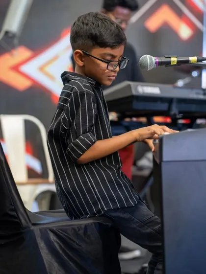 A young pianist focused and poised during his performance at the student showcase. It's incredible to watch our students command the stage with such confidence.