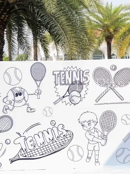 The blank canvas of the tennis-themed graffiti wall before the kids unleash their creativity.
