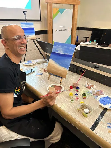 A participant from the GoLive workshop is all smiles as he adds the finishing touches to his beach scene. The laughter in these sessions is just as important as the art.