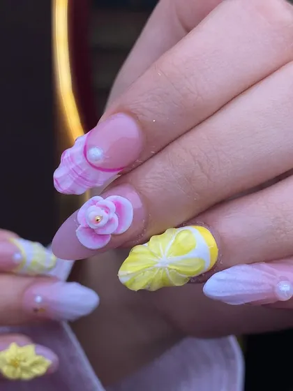 A playful and summery 3D set. These nails feature sculpted lemons, flowers, and seashell textures, showcasing the creative and fun possibilities of dimensional nail art.