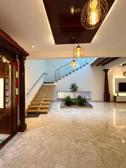 This view shows the relationship between the staircase, the central courtyard, and the traditional pooja room. The open design creates visual connections across the main living areas of the home.