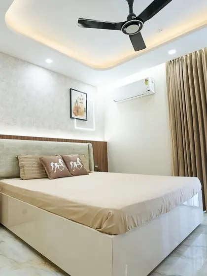 This bedroom is pure bliss, with a calming palette of white, beige, and brown. The backlit headboard with a textured wallpaper insert creates a warm and inviting focal point.