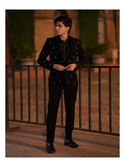 A few shots from a photoshoot for a men's ethnic wear brand, showcasing a sharp, all-black reception look.