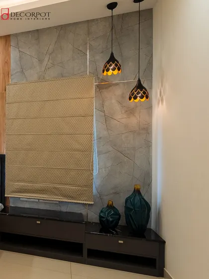 This image highlights a corner with a grey textured wall panel and elegant pendant lights. The combination of different materials and lighting creates a sophisticated and moody atmosphere.