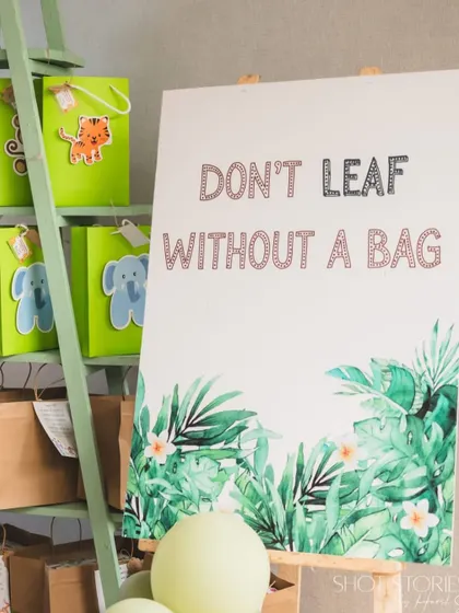 A clever sign at the gift station reads "Don't Leaf Without A Bag," adding a touch of punny humor to the jungle theme.