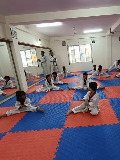 Students at our Banaswadi dojang work on their splits, building the flexibility needed for advanced Taekwondo techniques.