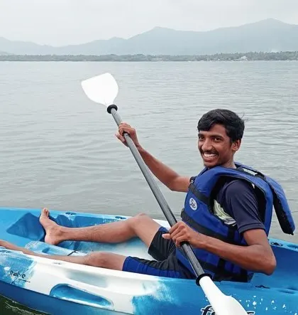 A participant enjoys a relaxing paddle in a solo kayak against the backdrop of the Karwar coastline.