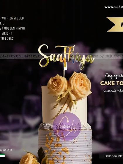 Another view of the "Saathiya" engagement topper, showcasing its glossy gold finish on a beautiful tiered cake with floral decorations.