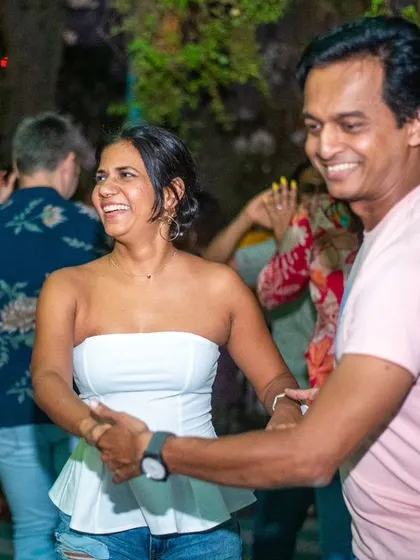 A smiling couple enjoying a dance. The white top and pink shirt create a bright and happy visual.