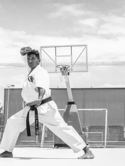 A black and white shot of me in a strong stance, demonstrating the focus and form that I teach to all my students.