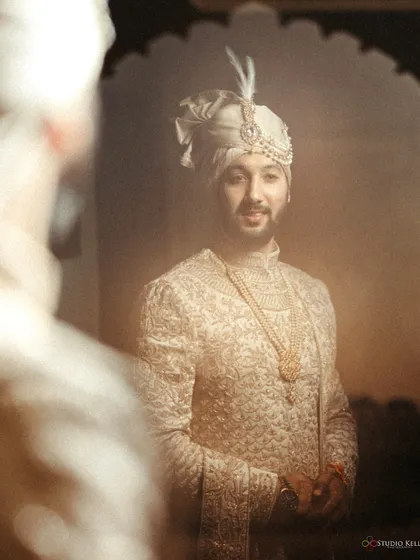 A classic portrait of the groom, looking sharp and ready for his wedding, captured in a mirror's reflection.