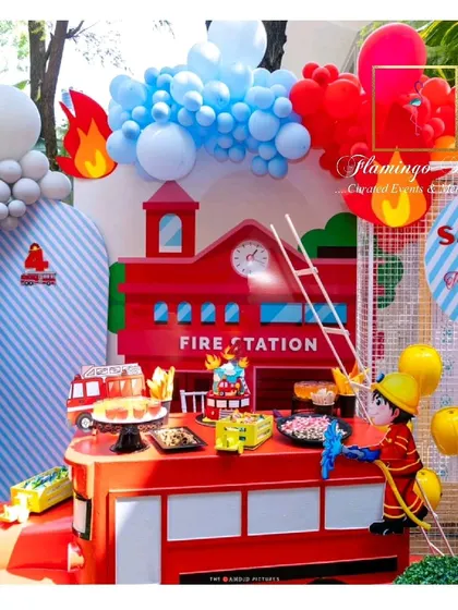 A wider shot of the impressive fire station dessert table and backdrop.