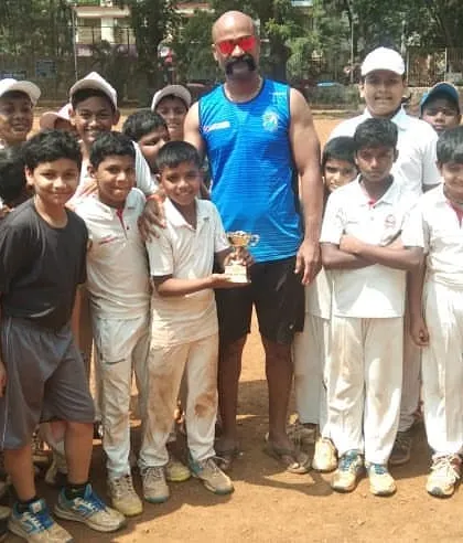 Vighnesh Shinde awarded 'Man of the Match' in our internal DSCA tournament, surrounded by his teammates and coaches.