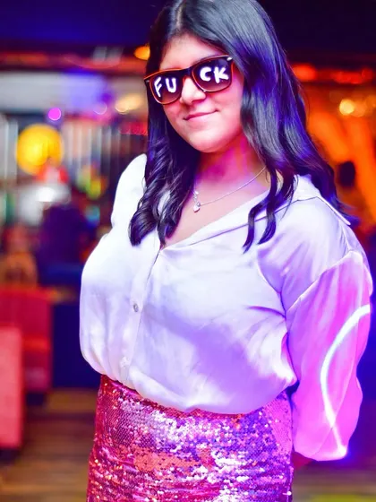 Rocking some fun shades and a sequin skirt, this partygoer embodies the fun and carefree spirit of Ladies' Night.