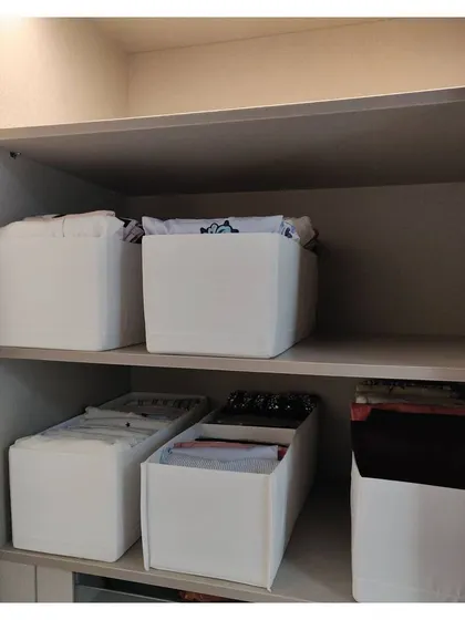 Using fabric boxes as drawer dividers is a great way to create compartments for different categories of clothing.