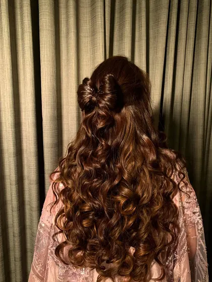 A simple but beautiful half-up style featuring a bow made from hair. This look is all about showcasing healthy, glossy curls.