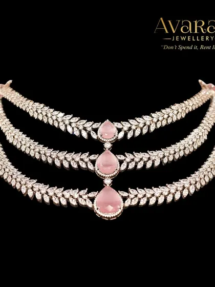 A product shot of the three-layered zircon necklace with pink stones. The delicate design and soft color make it a romantic and elegant choice for any special occasion.