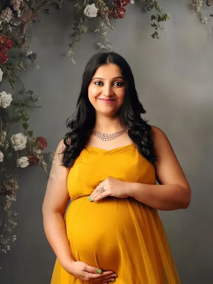 A close-up portrait that captures the gentle smile and radiant glow of this mom-to-be in her lovely yellow dress.
