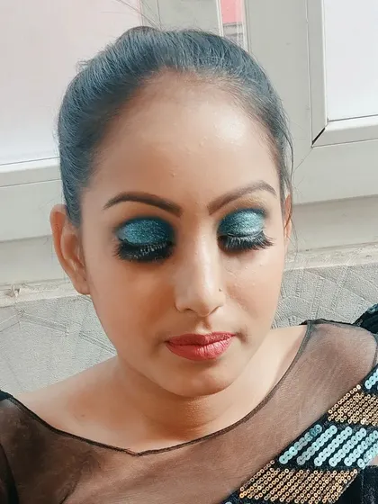 A stunning blue glitter cut-crease eye makeup look. This is perfect for a cocktail party or reception when you want your eyes to be the center of attention.