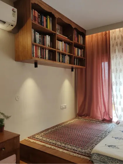 This enchanting wall-mounted bookcase seems to float above the ground, creating space for a reading nook below. The ornate design and Saras crane wallpaper at the back make it a truly magical home for books.