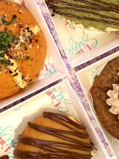 A closer look at the variety in our Rakhi assortment box. You can see the rich toppings on the Korean bun, the creamy Biscoff cookie, the chocolate drizzle on the bombolini, and the unique texture of the kunafa cheesecake.