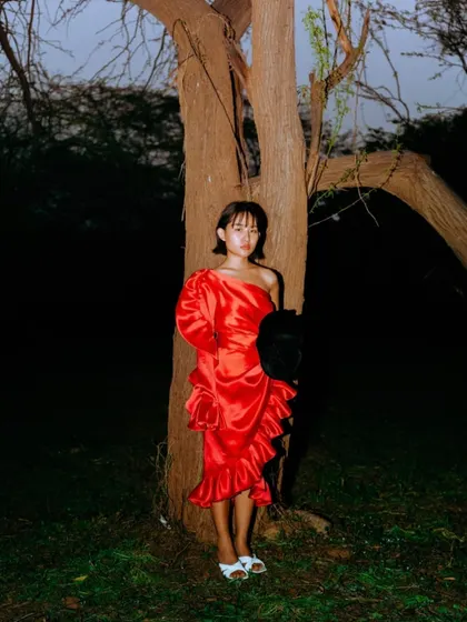 A vibrant shot from a spring fashion shoot. I styled this bold, red one-shoulder dress with ruffles against a dark, natural backdrop, using a flash to make the color pop and create a dramatic, high-contrast image.