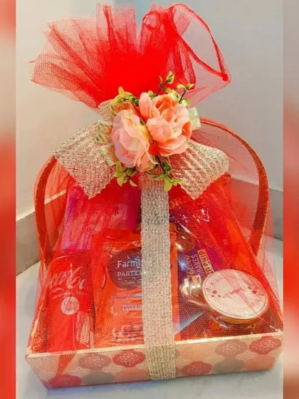 This Sweet and Savory basket is perfect for diverse teams. It's wrapped in festive red netting and contains a mix of snacks, a soft drink, and chocolates.