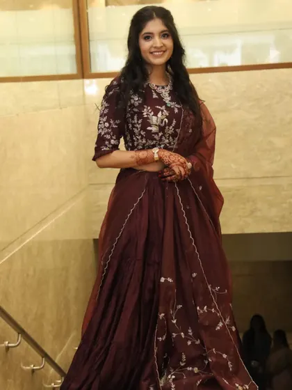 A full-length shot showing her beautiful maroon lehenga and how the soft makeup complements the rich color.